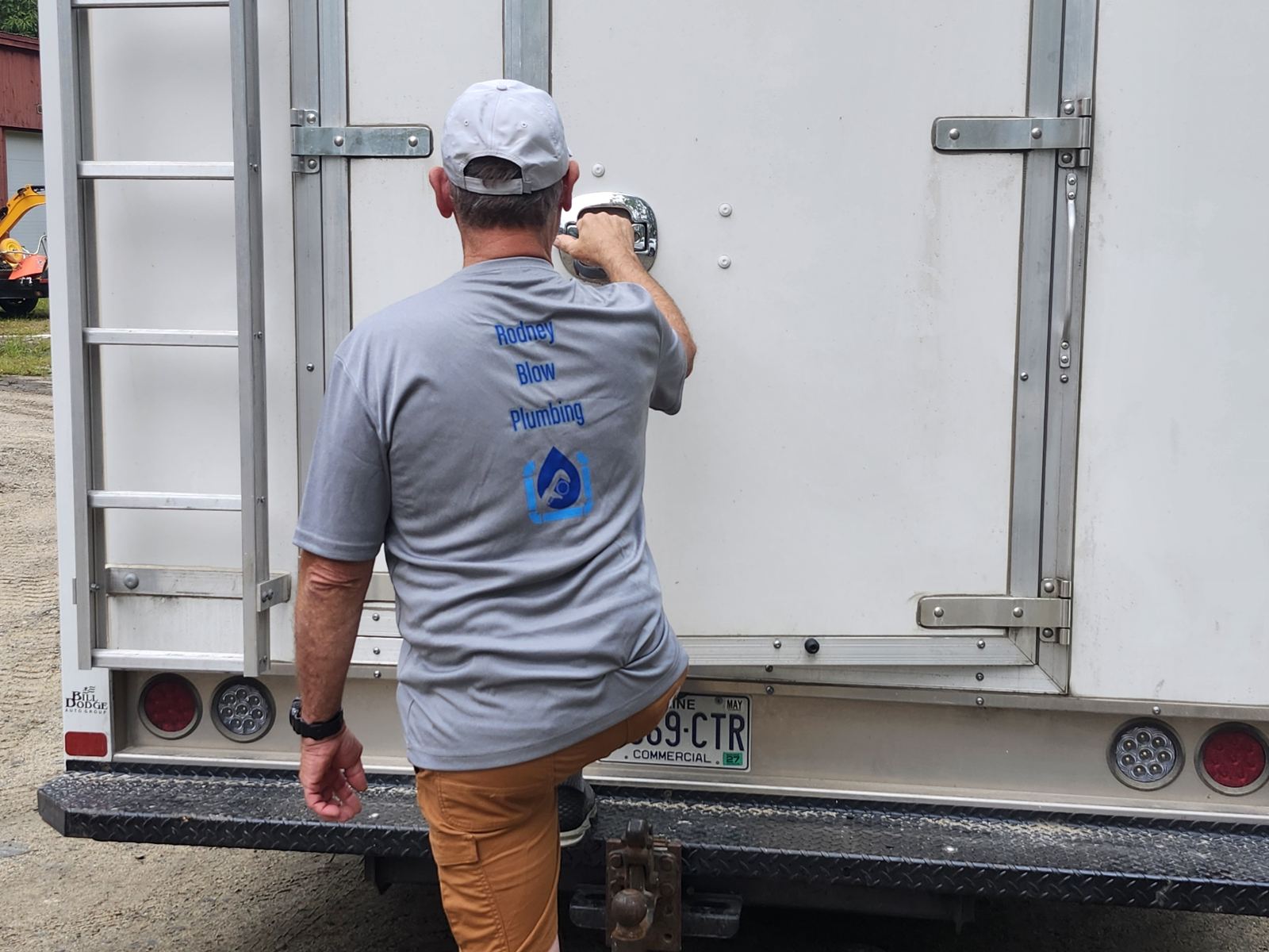 Rod in a Rodney Blow Plumbing shirt opening the service truck at a job site