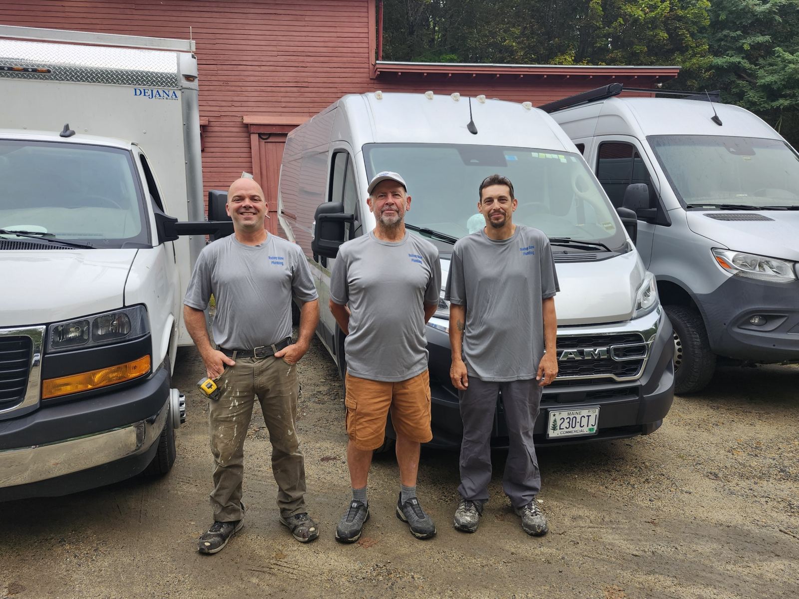 Rod and his crew in Rodney Blow Plumbing shirts in front of the company vans